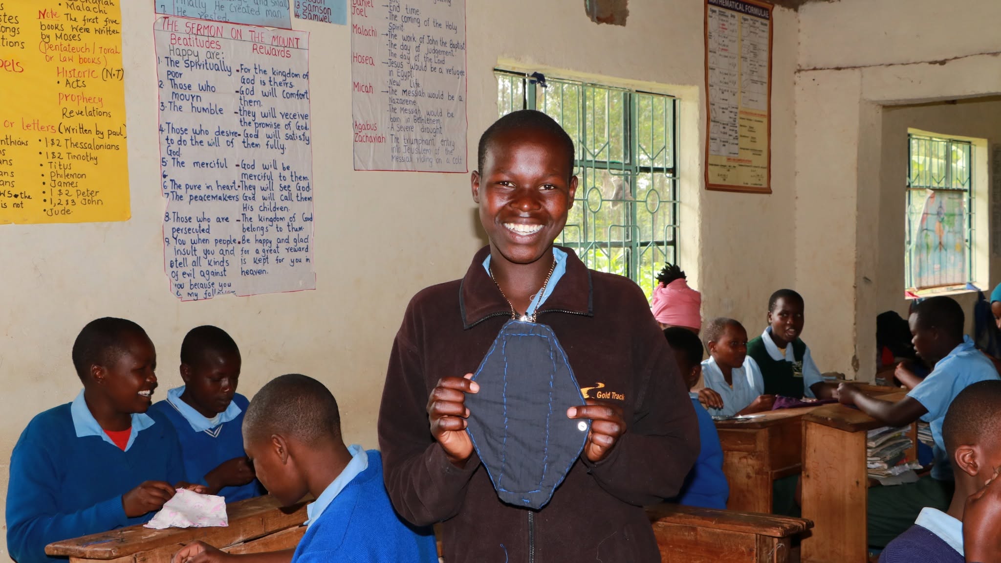 A facilitator demonstrating reusable pad use in class