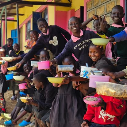 Children celebrating with their meal bowls